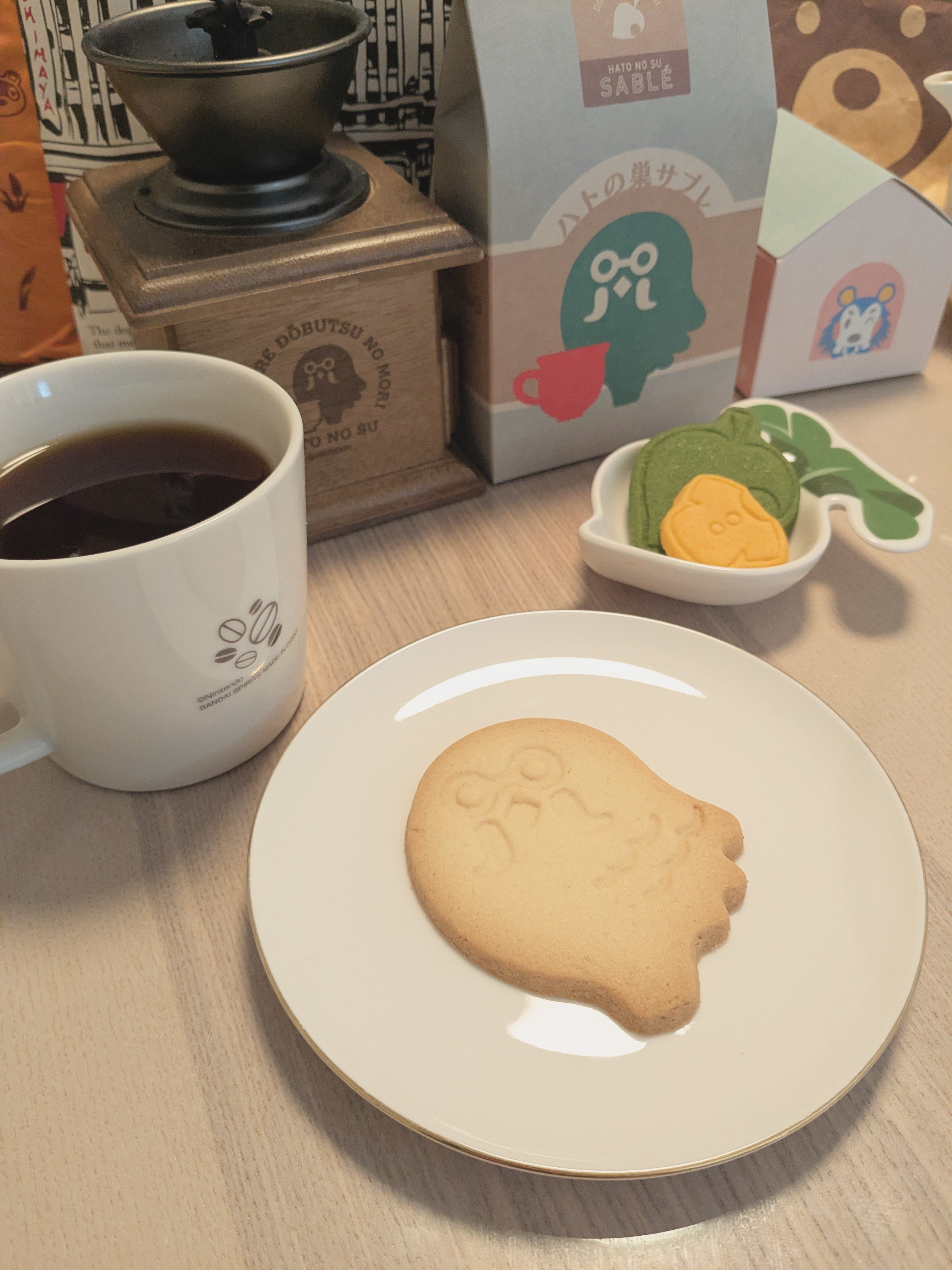 a pigeon-shaped sable biscuit on a plate with a cup of coffee in front of various animal crossing cafe decor