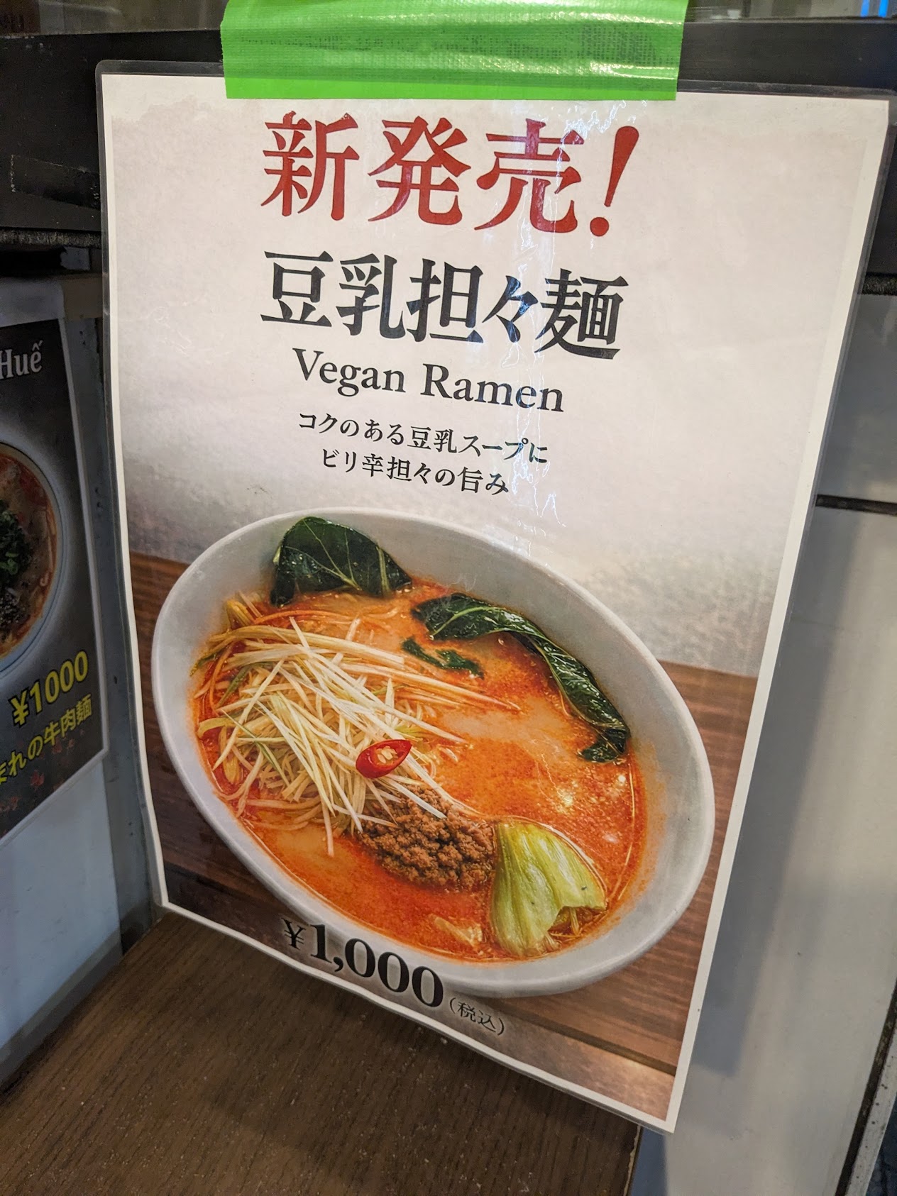 a sign advertising vegan ramen at a shop that also serves meat